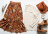 How to Wear Long Skirts Without Looking Frumpy: Style Tips for Every Body Type Modest outfit flat lay featuring a rust floral maxi skirt, long sleeve cream blouse, ankle boots and a terracotta hijab scarf on a white background